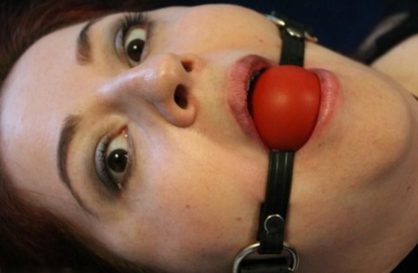 Redheaded girl is tied to a chair with a red ball gag in her mouth 39813556