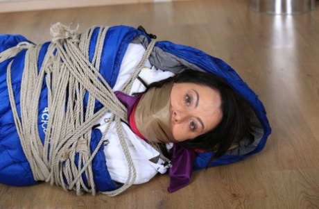 Brunette MILF is tied up and gagged while encased in a winter coat and bedroll 73839207