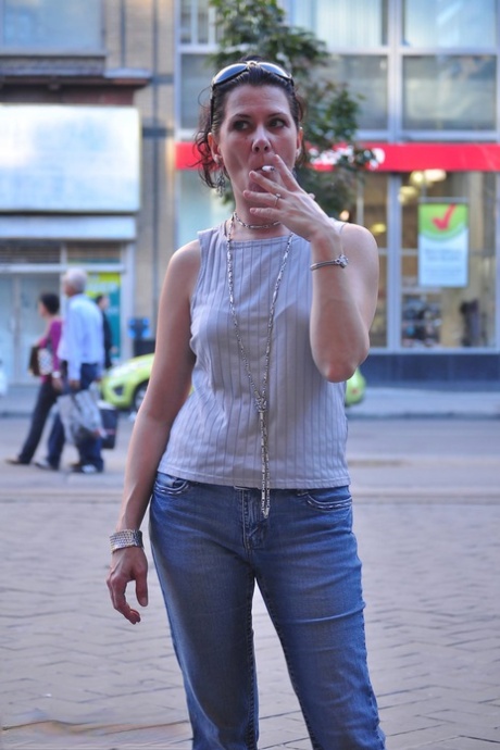 Brunette chick smokes a cigarette on a busy street while fully clothed 53662698