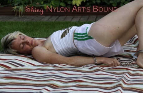 Caucasian woman is restrained with cuffs and chains in nylon shorts 57439403