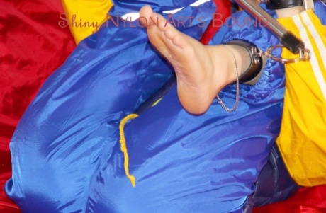 White girl struggles while attached to a spreader bar in nylon rainwear 92051165