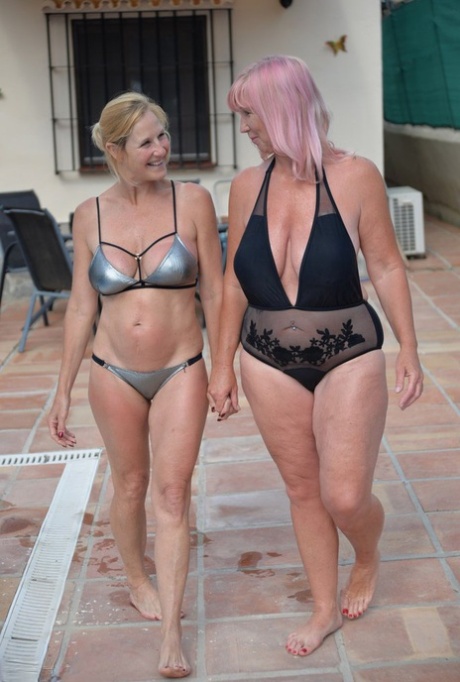 Mature blonde women frolic in a swimming pool with their swimsuits on 11158225