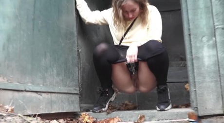Caucasian girl takes a piss in an outhouse while in a forest 45290041