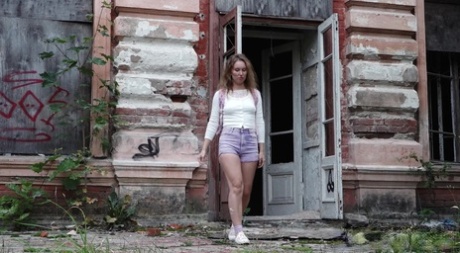Caucasian girl Rita takes a badly needed pee out front of a derelict building 19430965