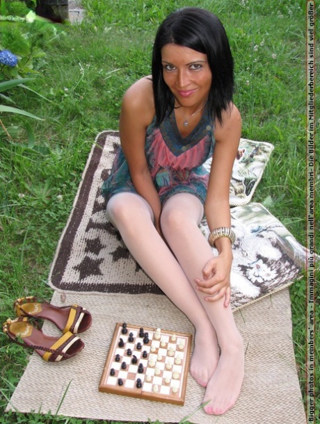 Dark-haired girl Barbara removes her shoes while playing chess in stockings 98006451