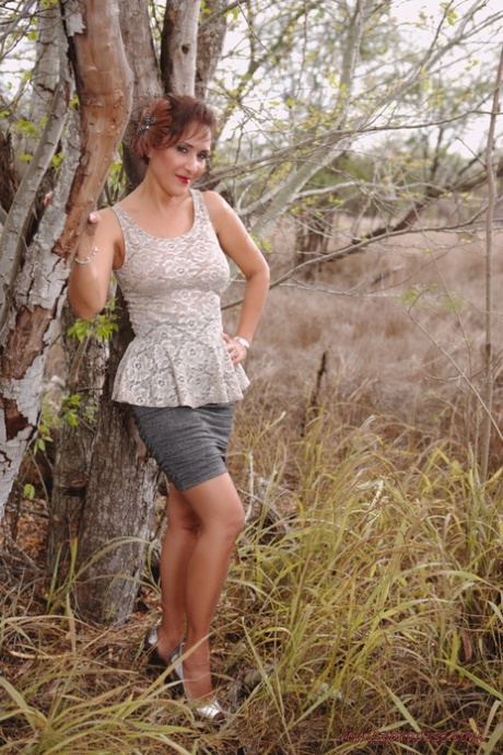 Mature pinup model Roni Ford kicks off pumps wearing retro lingerie in woods 32267967
